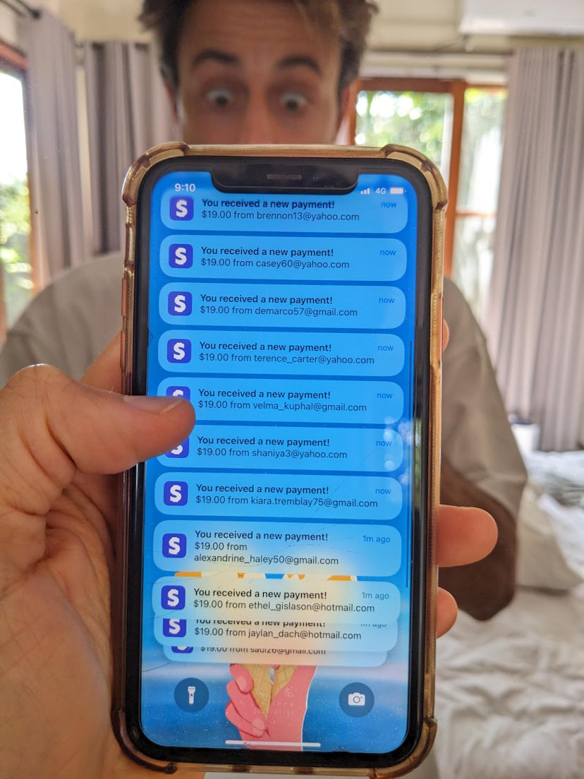 A person taking a selfie showing off their fake Stripe notifications